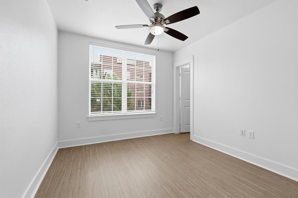 4110 Fairmount Street, Unit 1009 Dallas, TX 75219 - Photo 25 of 35 an empty room with wooden floor ceiling fan and windows
