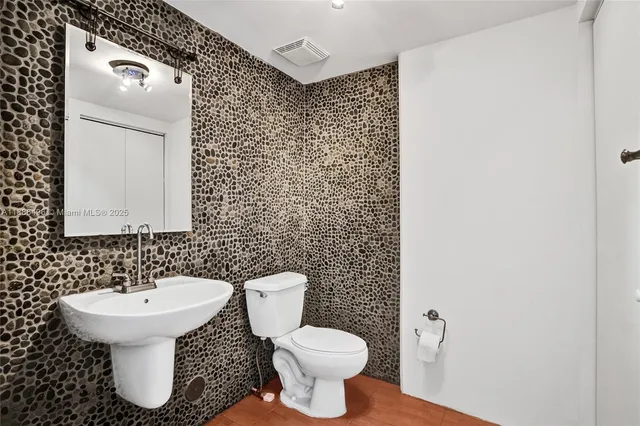 a bathroom with a toilet sink and mirror