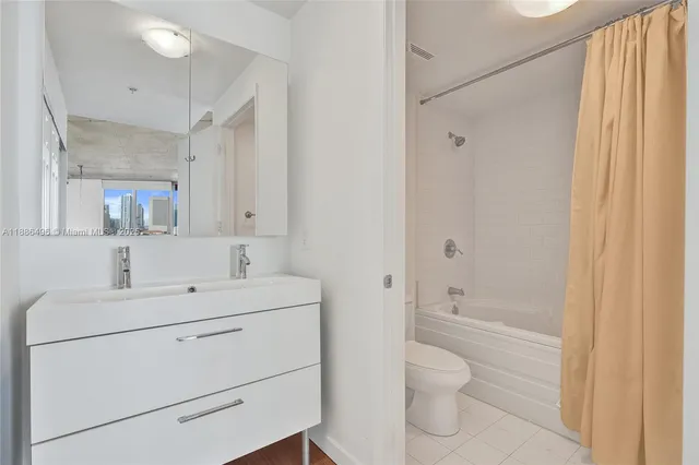 a bathroom with a toilet sink vanity and bathtub