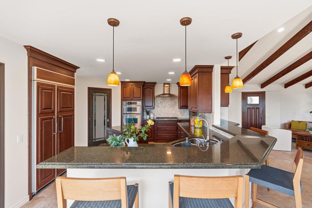 13319 Pacer Lane Poway, CA 92064 - Photo 10 of 75 a kitchen with a refrigerator a sink and living room view