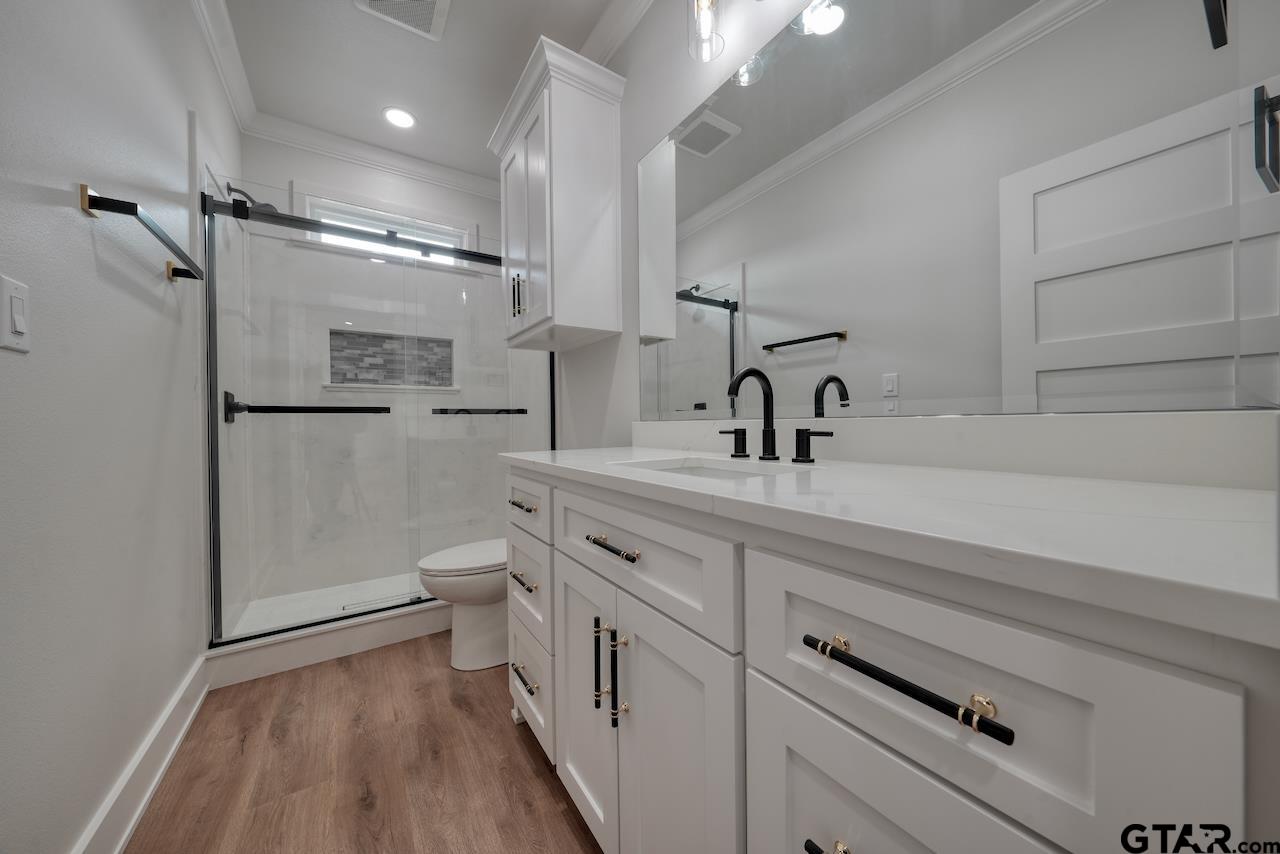 19383 Ridge Point Circle Lindale, TX 75771 - Photo 33 of 48 a bathroom with a double vanity sink a toilet and a mirror