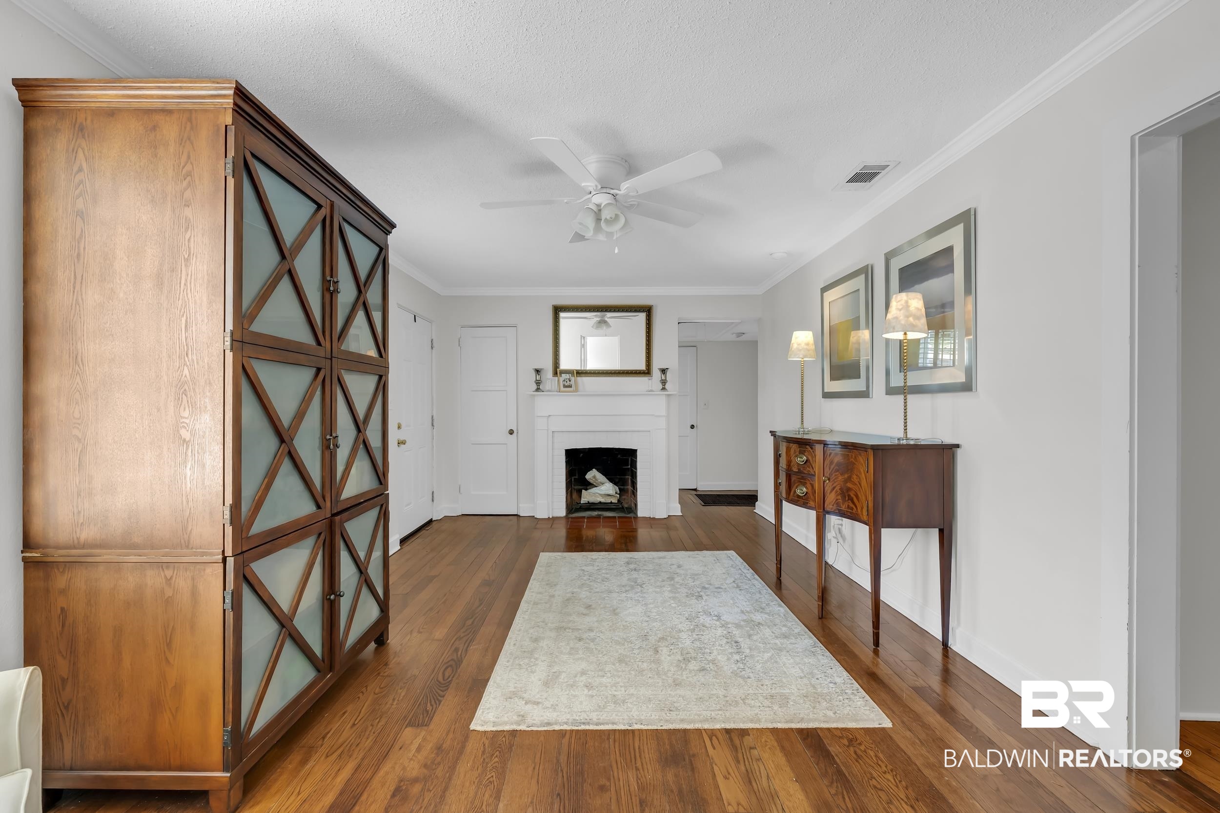 18 York Place Mobile, AL 36608 - Photo 6 of 27 Living area with crown molding, dark wood-style flooring, ceiling fan, a fireplace with flush hearth, and a textured ceiling