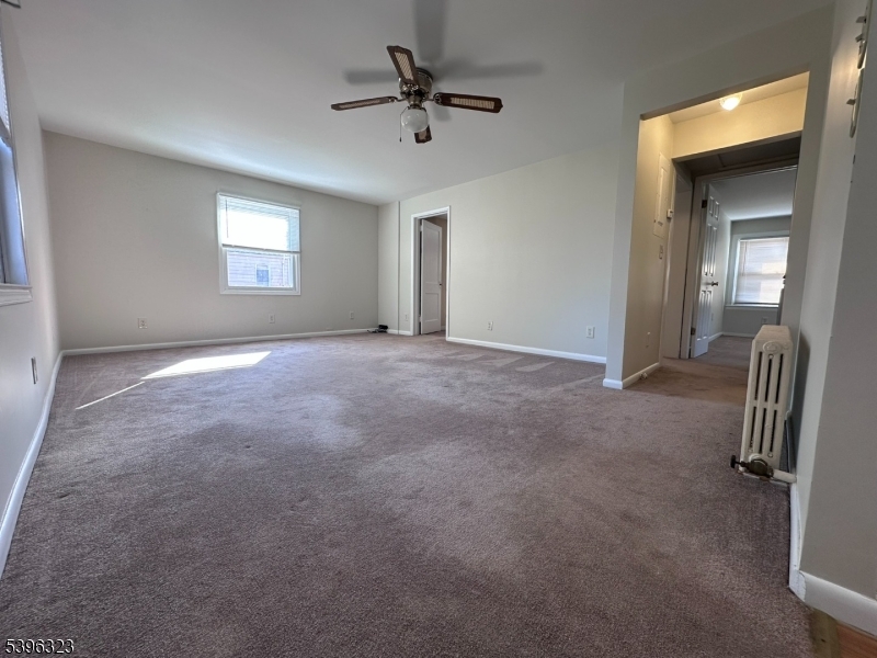 376 South Main Street, Unit 1 Wharton, NJ 07885 - Photo 4 of 14 an empty room with windows and fan