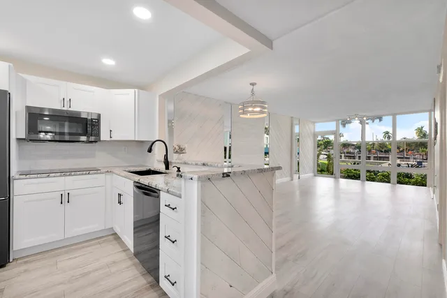 a kitchen with stainless steel appliances a sink a stove top oven a counter space and cabinets