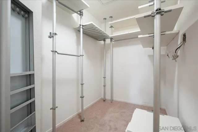 a view of walk in closet with empty racks