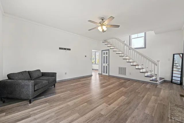 a living room with furniture and a wooden floor