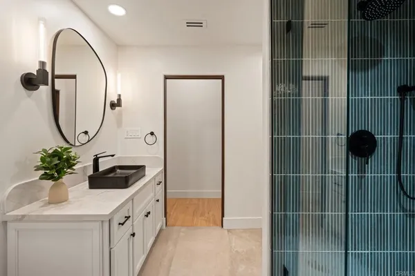 a spacious bedroom with a bed mirror and window