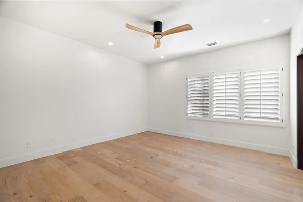 a dining room with wooden floor a chandelier a glass table and chairs