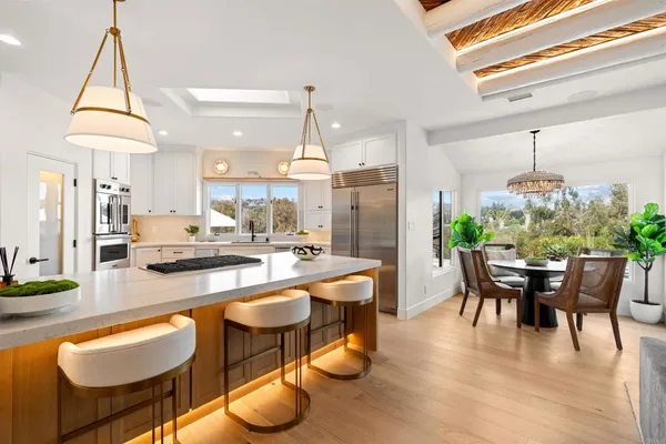 a kitchen with a stove a sink dishwasher a kitchen island with wooden cabinets and floor