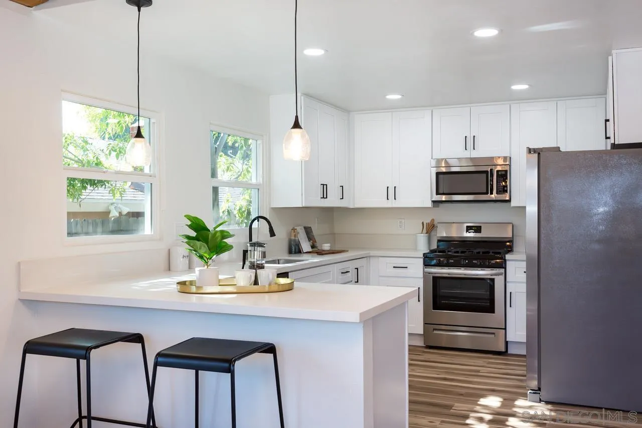 2610 Glebe Road Lemon Grove, CA 91945 - Photo 4 of 31 a kitchen with a sink a stove a kitchen island with a window and stainless steel appliances