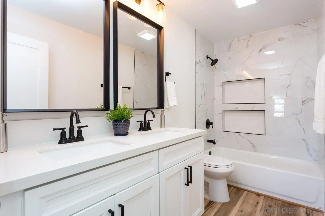 2610 Glebe Road Lemon Grove, CA 91945 - Photo 9 of 31 a bathroom with a toilet a sink a mirror a bathtub and vanity