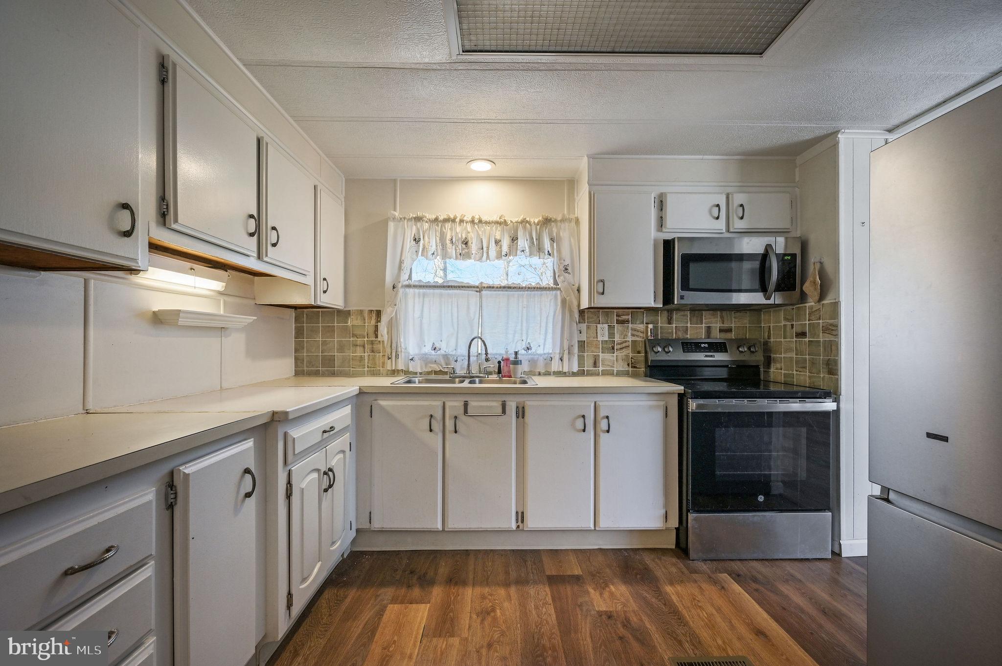 3 Patterson Drive Georgetown, DE 19947 - Photo 12 of 25 a kitchen with granite countertop a sink cabinets and stainless steel appliances