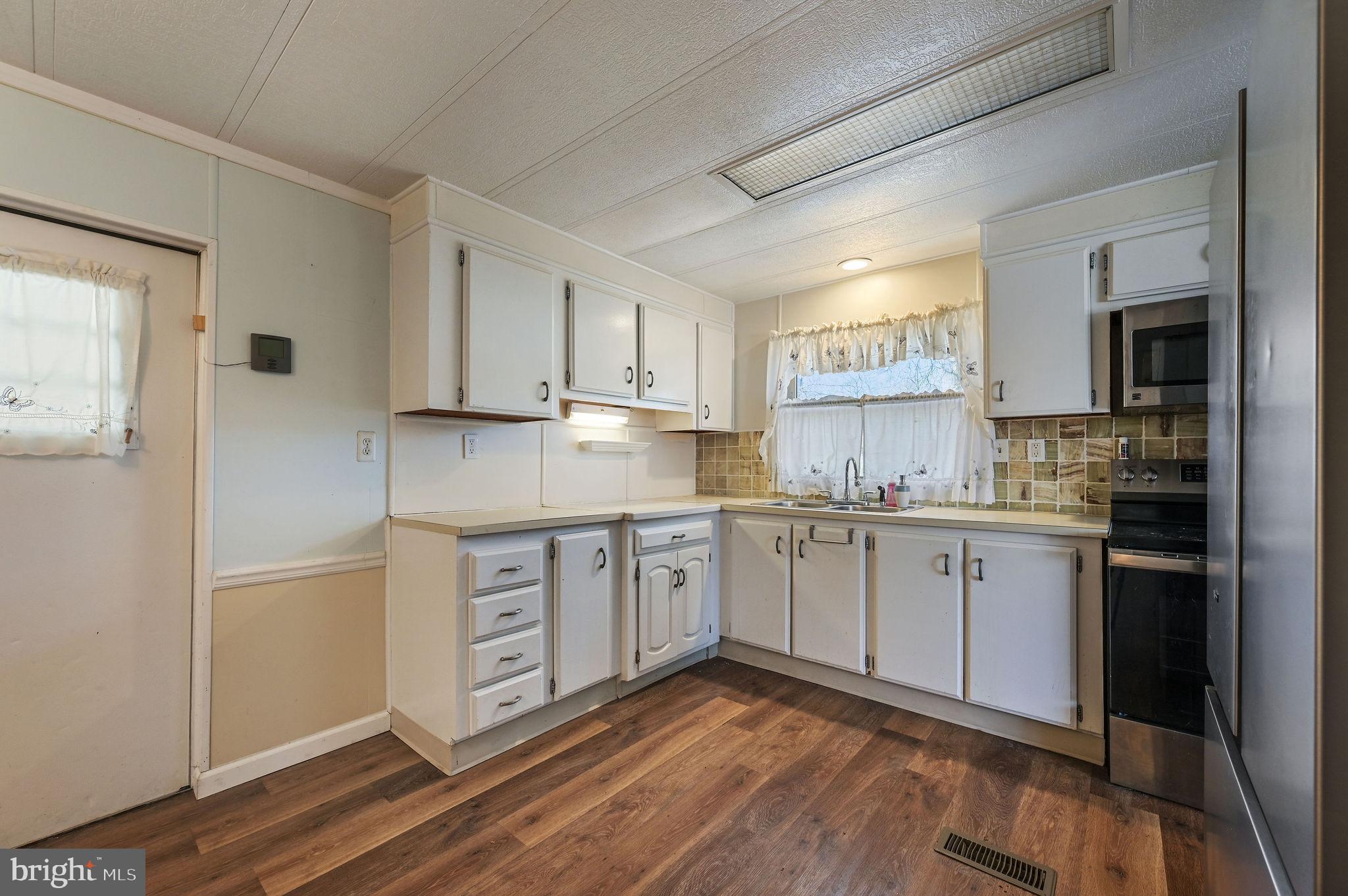 3 Patterson Drive Georgetown, DE 19947 - Photo 13 of 25 a kitchen with granite countertop white cabinets and white appliances