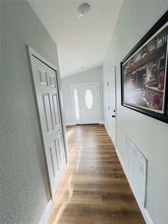 12195 71st Way Largo, FL 33773 - Photo 6 of 31 a view of a hallway with wooden floor and staircase