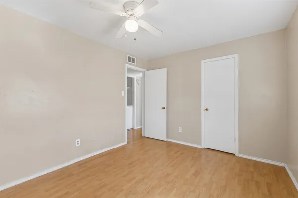an empty room with a ceiling fan and a window