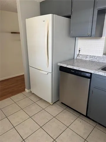 a white refrigerator freezer and a stove sitting inside of a kitchen
