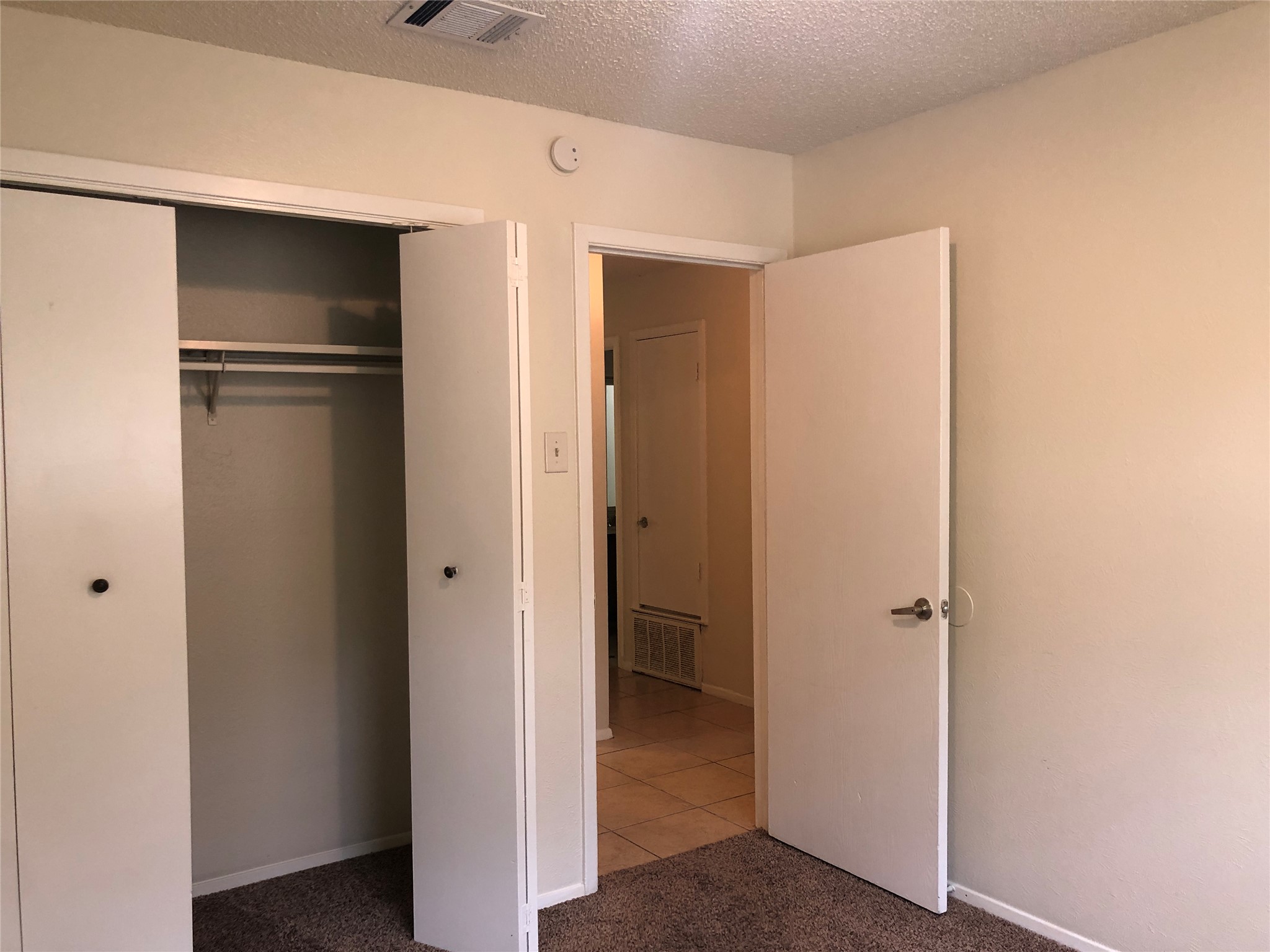 11510 Walnut Ridge Drive, Unit B Austin, TX 78753 - Photo 13 of 18 Comfortable bedroom features plush carpeting and a functional closet with folding doors.