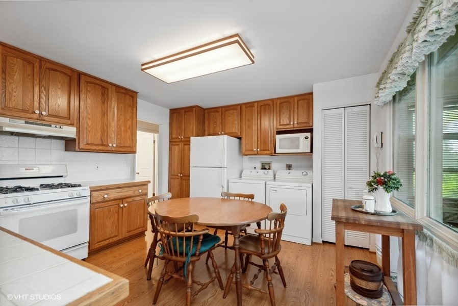 642 Deerpath Road East Dundee, IL 60118 - Photo 6 of 13 a kitchen with stainless steel appliances a dining table chairs refrigerator and sink