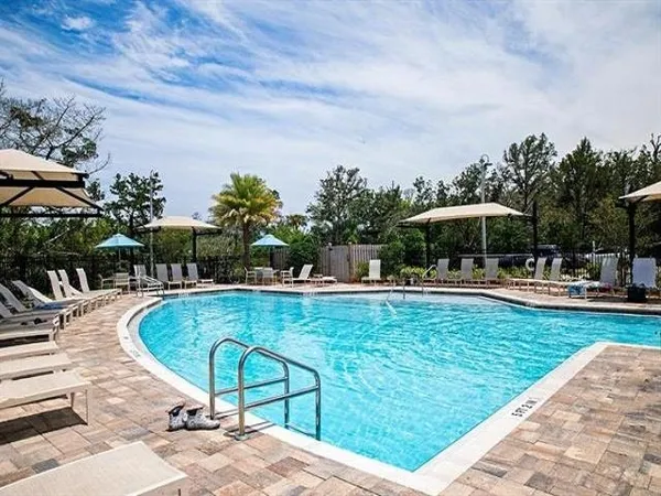a view of a swimming pool with a table and chairs under an umbrella