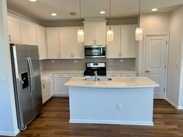 a kitchen with stainless steel appliances a refrigerator stove microwave and cabinets