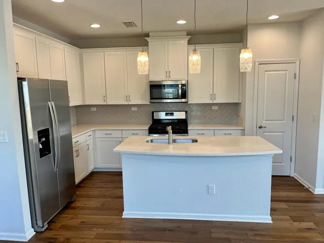 a kitchen with stainless steel appliances a refrigerator stove microwave and cabinets