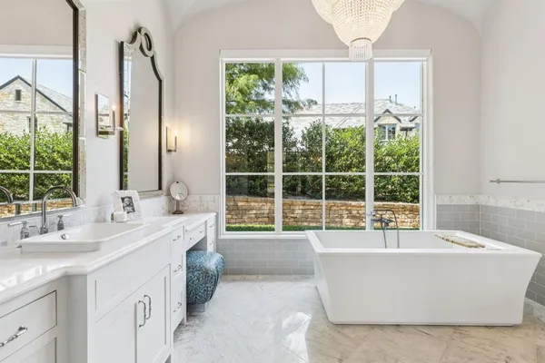 a spacious bathroom with a tub sink and mirror