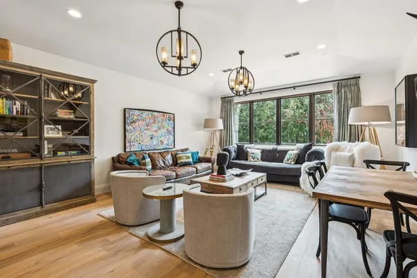 a living room with furniture a chandelier and a dining table