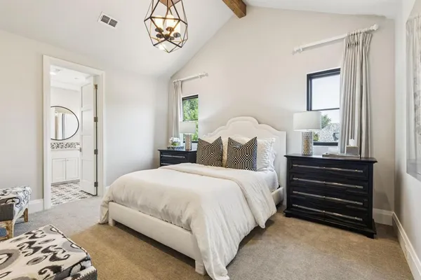 a bedroom with a bed and a chandelier