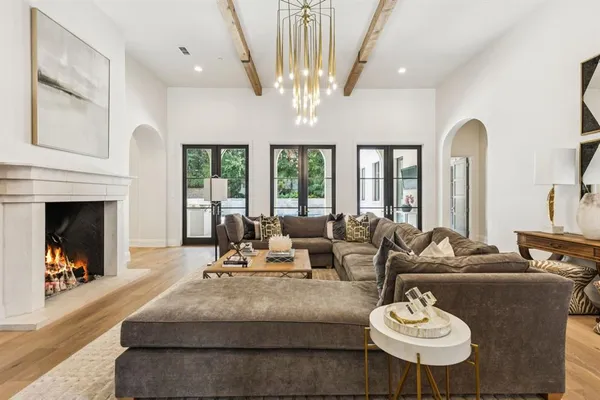 a living room with furniture a chandelier and a fireplace