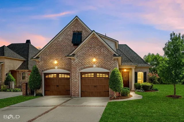 a front view of a house with a yard and garage