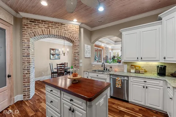 a kitchen with stainless steel appliances granite countertop a sink a stove and cabinets
