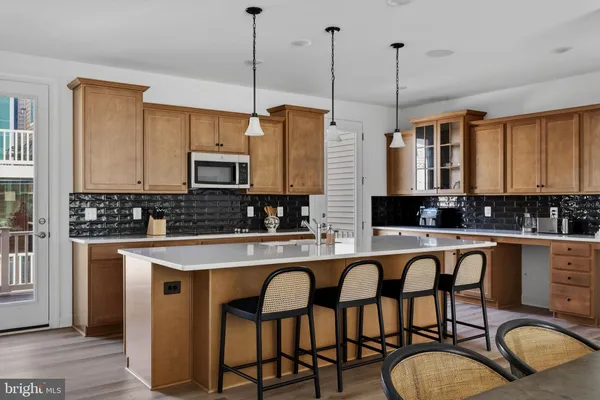 a kitchen with stainless steel appliances granite countertop a stove a sink a microwave a center island and cabinets