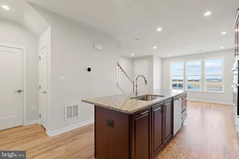 a kitchen with stainless steel appliances granite countertop a sink stove and wooden floor