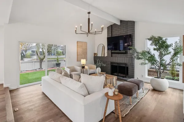 a living room with furniture a fireplace and a chandelier