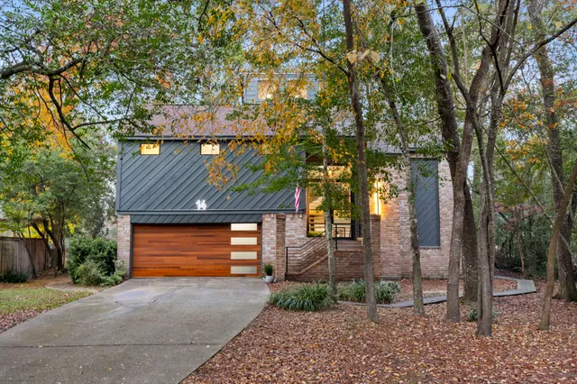 a front view of a house with a yard and trees