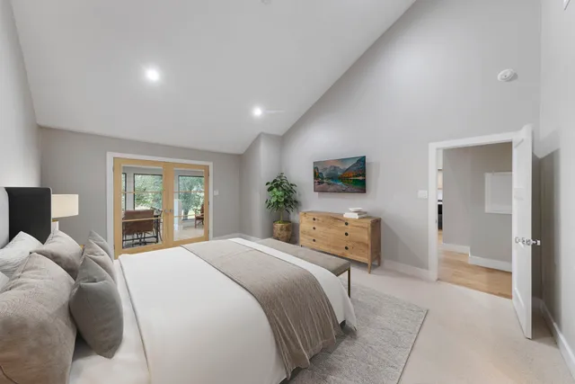 a bedroom with a large bed couch and a flat tv screen