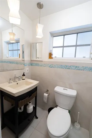 a bathroom with a toilet a sink and a window