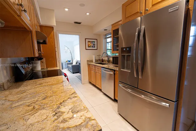 a kitchen with stainless steel appliances granite countertop a refrigerator and a sink