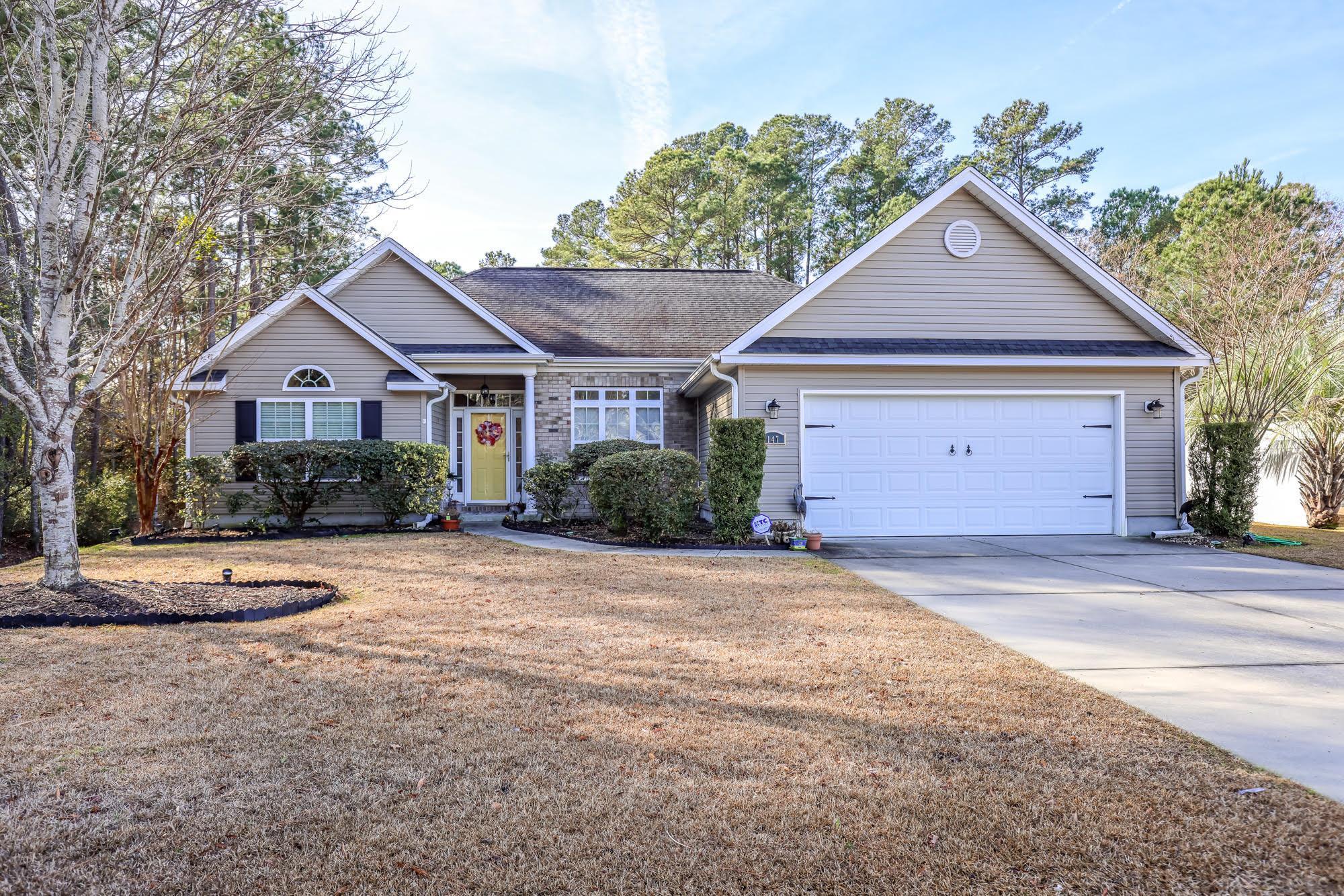 Ranch-style house featuring driveway, a front yard, an attached garage, and roof with shingles