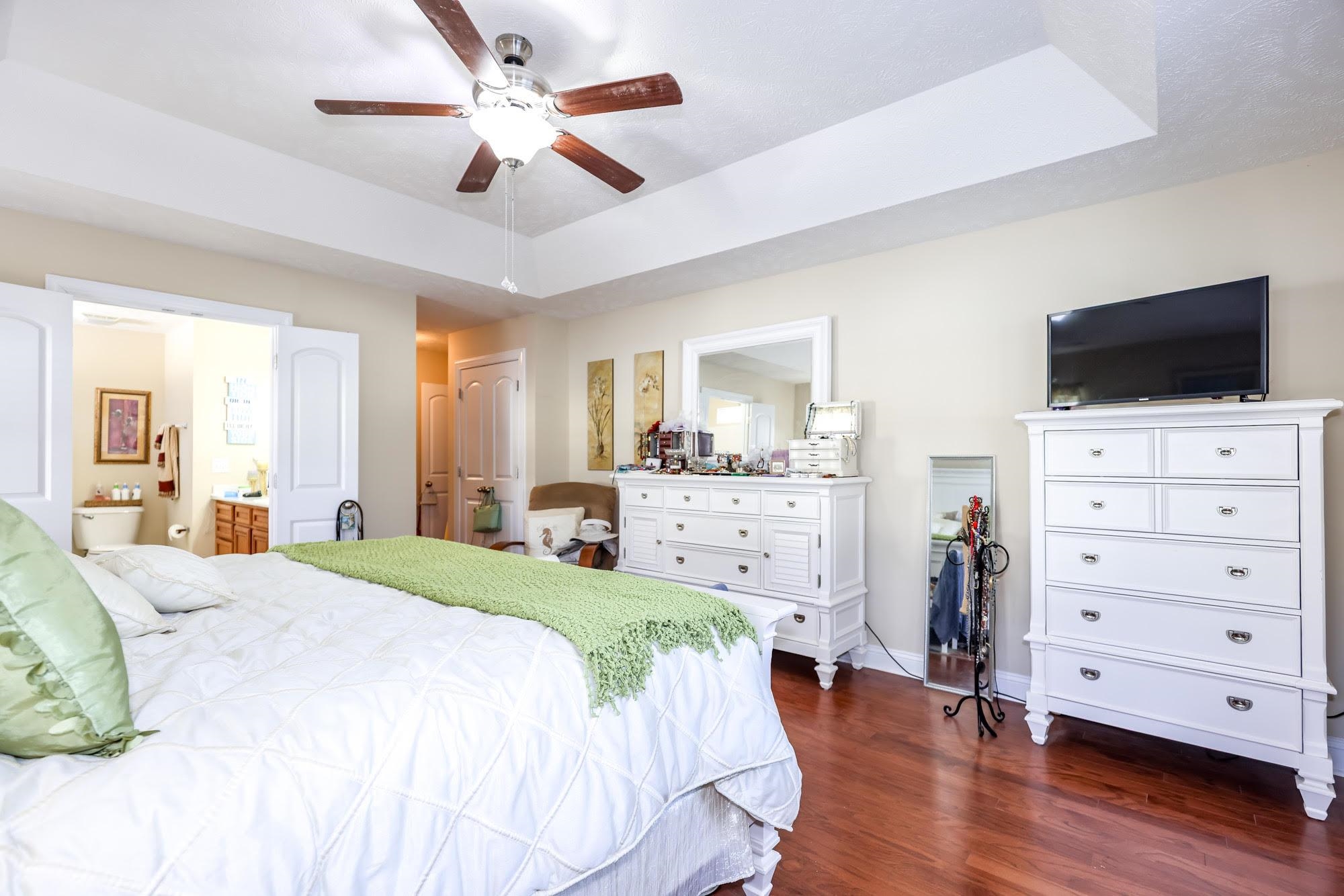 147 Quail Hollow Road Myrtle Beach, SC 29579 - Photo 12 of 35 Bedroom featuring a raised ceiling, dark wood-type flooring, ceiling fan, and ensuite bath