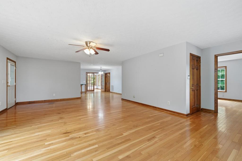 176 Big Oak Tree Road Northwest Adairsville, GA 30103 - Photo 23 of 77 a view of an empty room with wooden floor and a ceiling fan