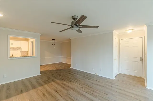 a view of a room with wooden floor and a ceiling fan