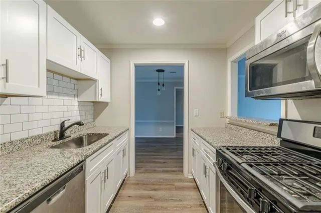 a kitchen with granite countertop a sink and a stove top oven