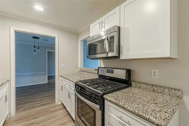 a kitchen with stainless steel appliances granite countertop a stove and a microwave