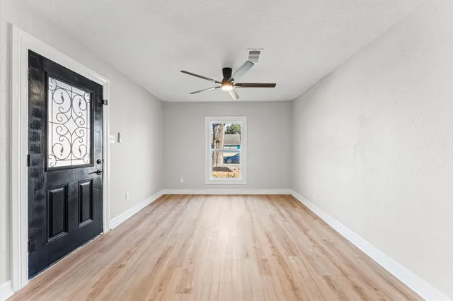 wooden floor in an empty room with a window