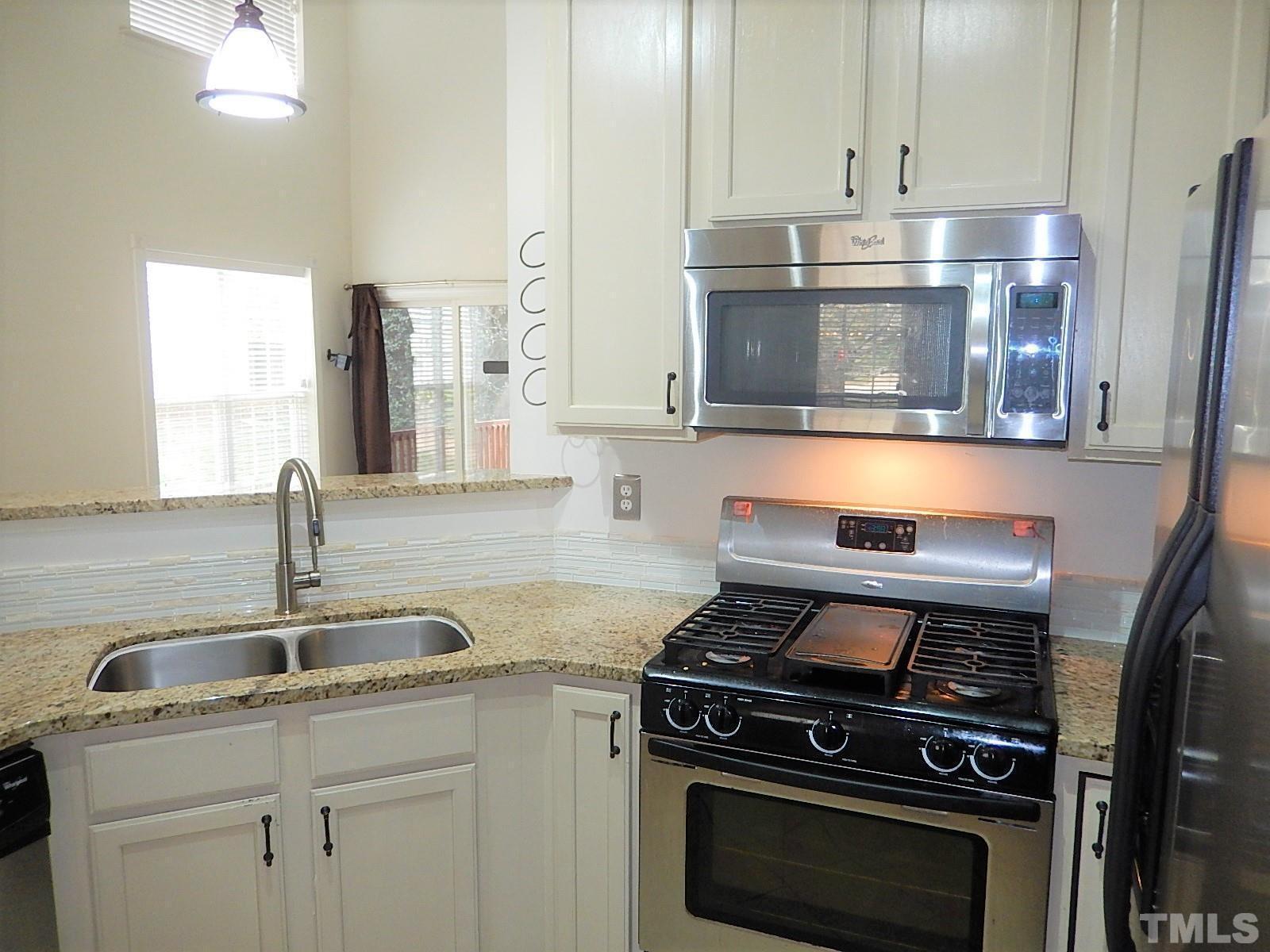 4717 Delta Ridge Court Raleigh, NC 27612 - Photo 8 of 30 a kitchen with granite countertop a stove and a sink