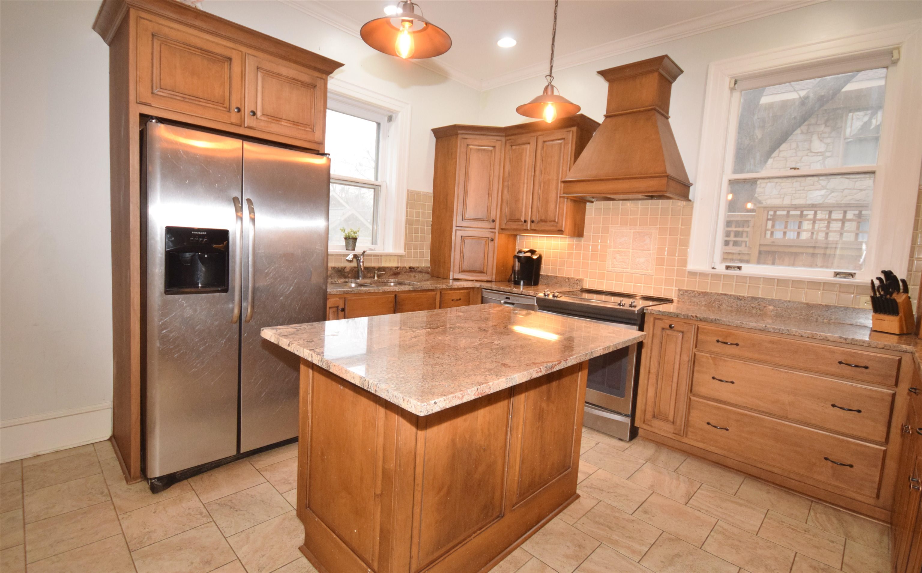 263 Stonewall Street Memphis, TN 38112 - Photo 12 of 25 a kitchen with stainless steel appliances granite countertop a sink a stove and a refrigerator