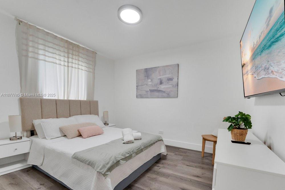 180 Northwest 69th Street Miami, FL 33150 - Photo 16 of 31 a room with a bed and a potted plant