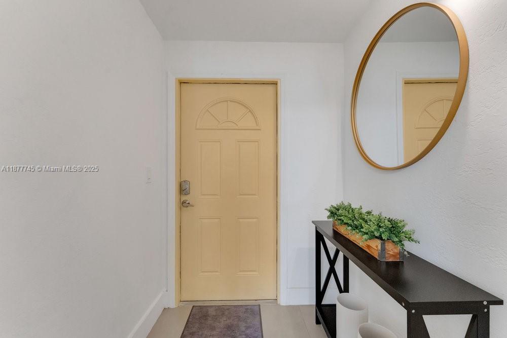 180 Northwest 69th Street Miami, FL 33150 - Photo 2 of 31 a view of a hallway with paintings on the wall