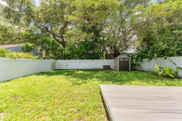 a backyard of a house with plants and tree